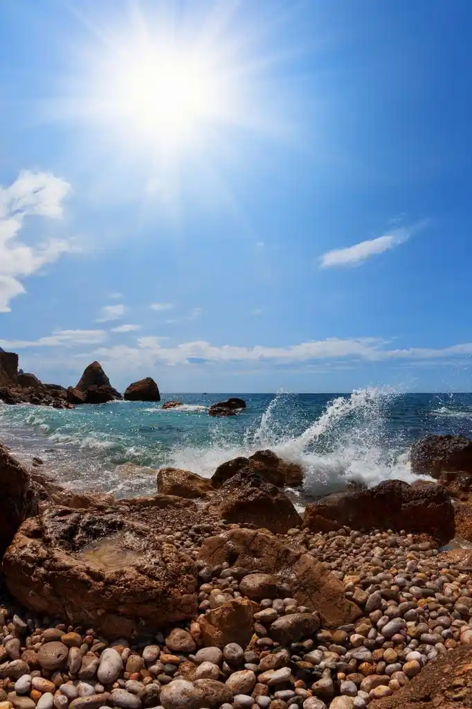 海滩,海滩.岩石, 大海和太阳在一片蓝天
