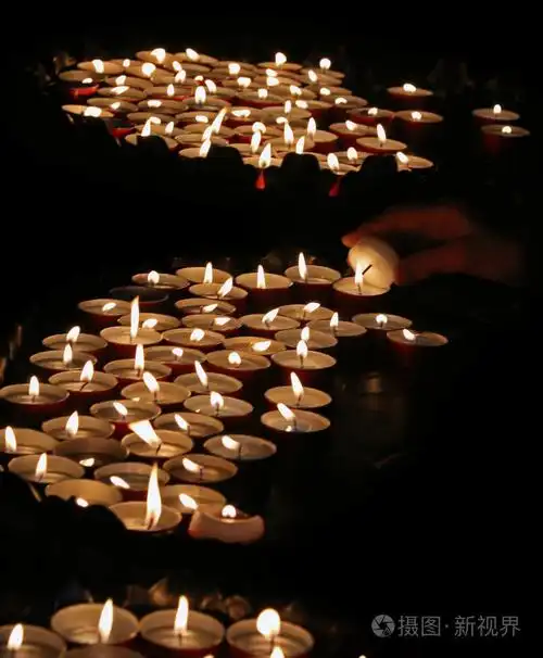 一名老妇手点燃蜡烛祈祷