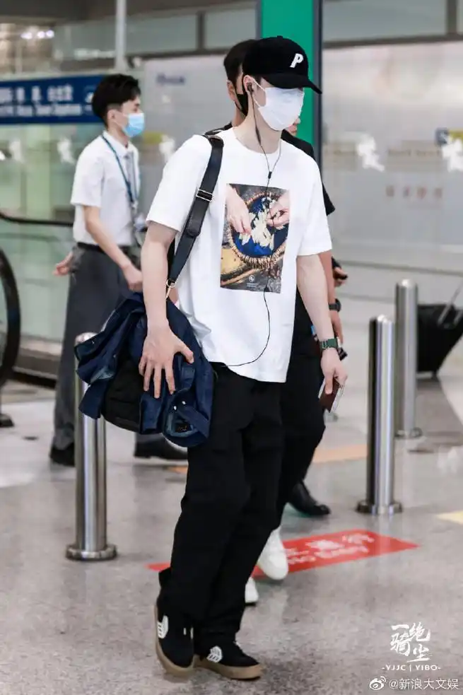 组图:王一博出发看秀穿白t走机场 外套挂在背包上似清爽男高