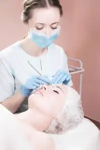 在美容院用黑头去除剂对女性面部进行深层清洁.照片