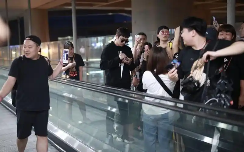 张彬彬给粉丝签完名后,在助理的陪同下继续前行.