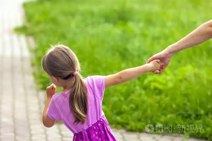 小女孩牵着她的母亲的手.家庭关系让步