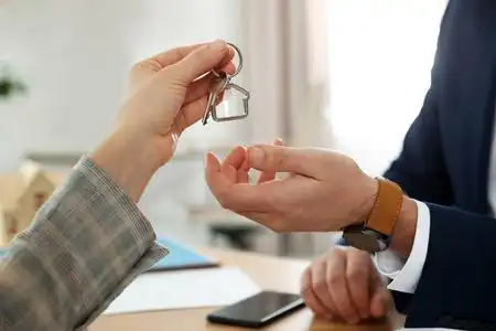 房地产经纪人在办公室给客户带小饰物的钥匙照片