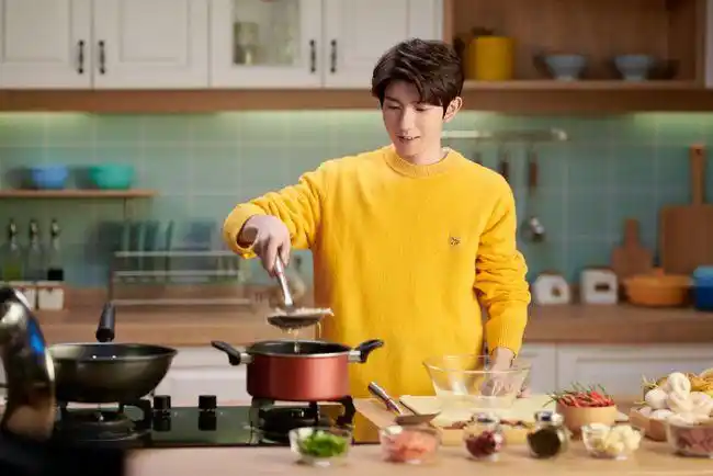 王源身穿黄橙色圆领毛衣,简约纯色设计奠定暖男氛围基调,小巧的破牌