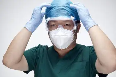 穿手术服戴手术帽护目镜手术手套的男性医生