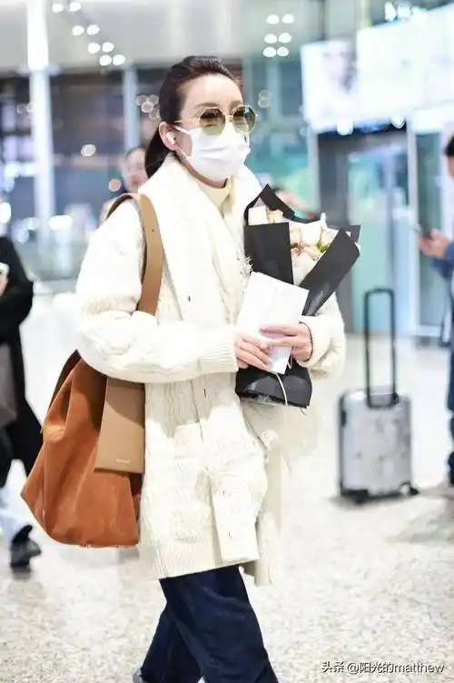 街拍:秦海璐白色毛衣开衫 牛仔裤 麂皮单肩包 墨镜温暖时髦_上海_机场