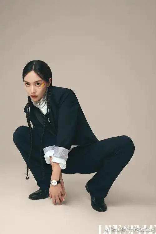 王霏霏fei身着黑色西装套装,利落干练,袖口条纹翻边别致点睛,一举拿