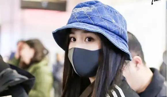 杨幂现身机场带口罩遮面包裹严实十分低调