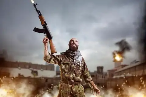 大胡子的恐怖分子手中的步枪站在爆炸和火中恐怖主义和恐怖,卡其色 i>