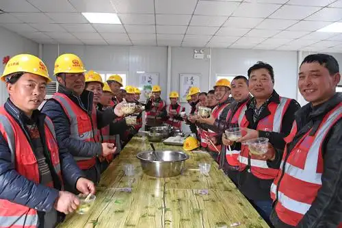 中铁四局建筑工人们在工地食堂聚餐吃饺子(2月4日摄).