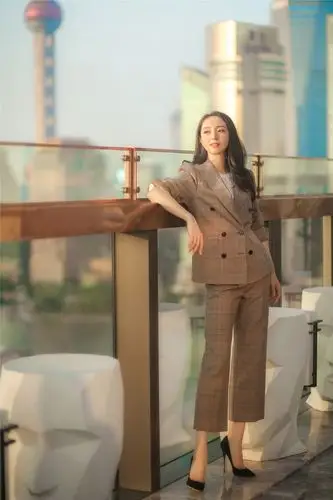 身穿一套棕色细格子的套装,职业风范瞬间提升,九分裤和高跟鞋的互相