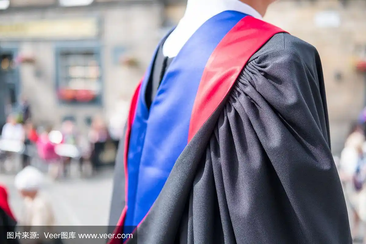 一个身份不明的研究生的背影,模糊背景的人们在毕业典礼上.