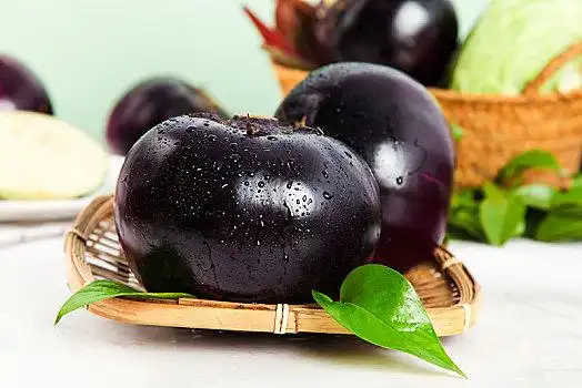 石板上放着一筐紫圆茄子