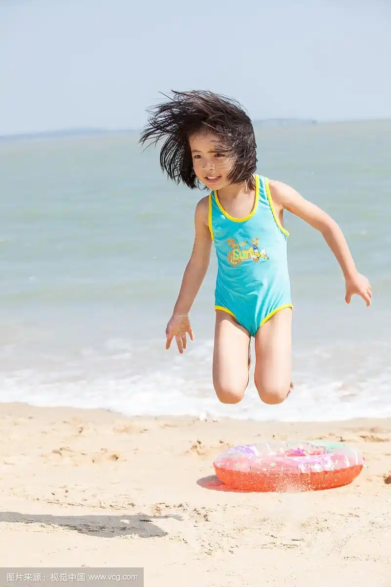 小女孩赤脚在沙滩上跳跃