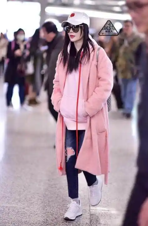 李小璐近日现身机场,穿着一件粉红色卫衣,外面的大衣也是粉红色的