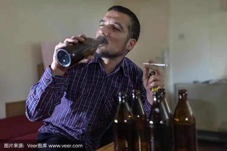 年轻悲伤的醉酒男子喝啤酒和酒精感到浪费,孤独和绝望的痛苦和情绪