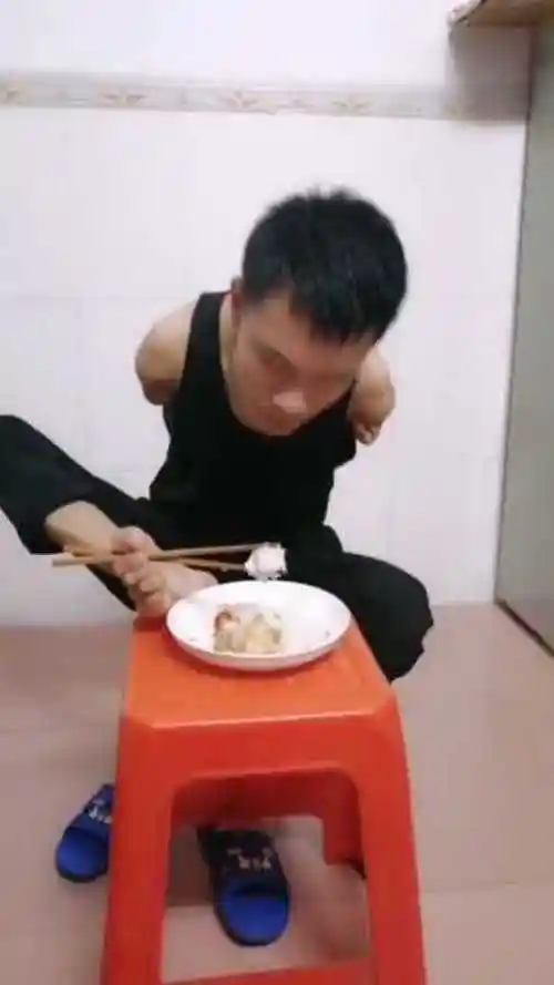 残疾小伙用脚吃饭,看这艰难模样,活着就是痛苦!