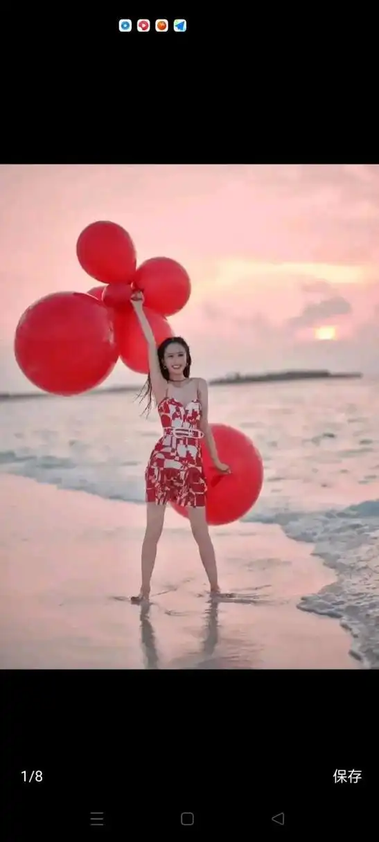 身穿红色泳装的佟丽娅,光着脚y,手拿红色气球,一副喜庆的样子.