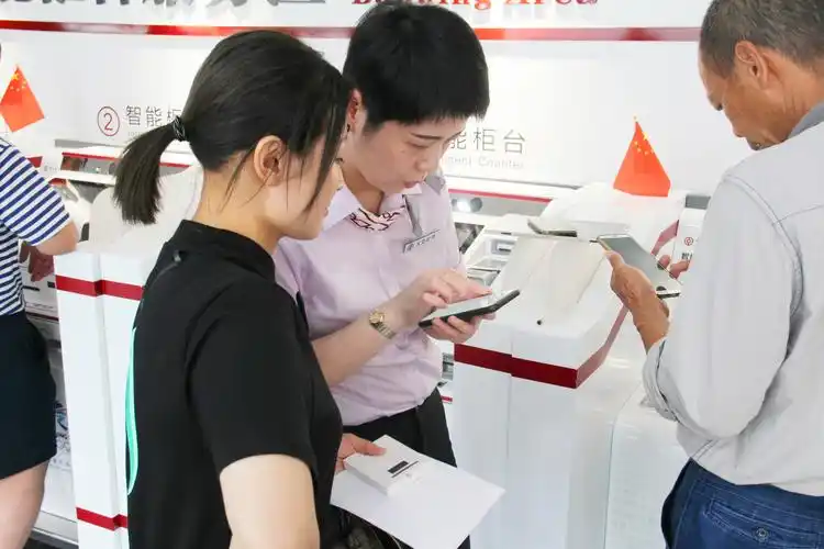 (大堂经理指导客户操作使用手机银行)
