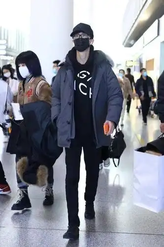 许嵩穿黑色连帽卫衣外搭羽绒服现身机场头戴黑色棒球帽简约帅气