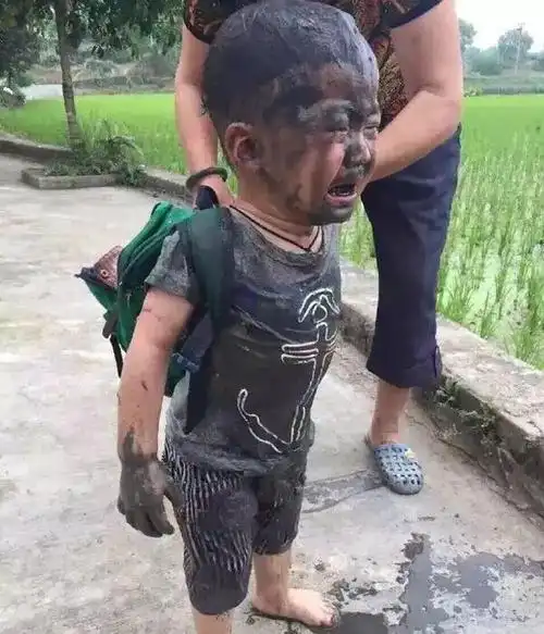 孩子放学回家到处跑不小心掉进田里了全身都沾满了泥巴