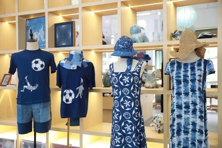 新华社记者 周宣妮 摄入夜时分,在"村超"赛场周边的非遗展销区内,许多