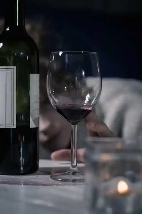 喝酒的年轻女人图片-坐在桌子旁边倒酒的女人素材-高清图片-摄影照片