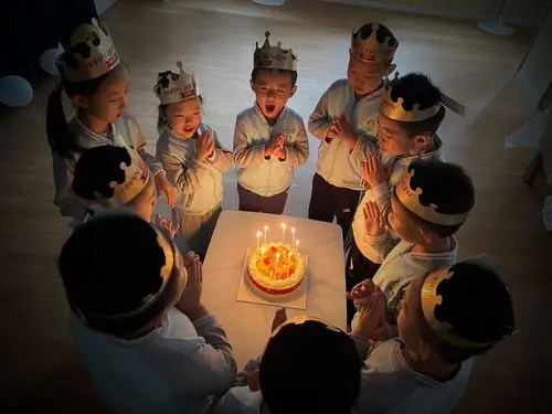孩子们围坐在桌子周围,一同唱起《生日快乐》的祝福,共同吹灭生日蜡烛