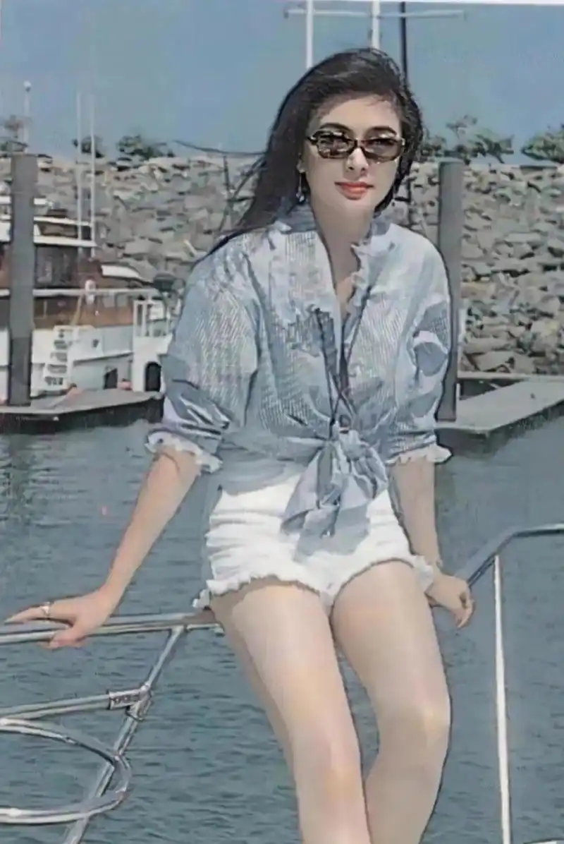 上世纪90年代,在海边度假的关之琳站在游艇的护栏上拍了一张照片.