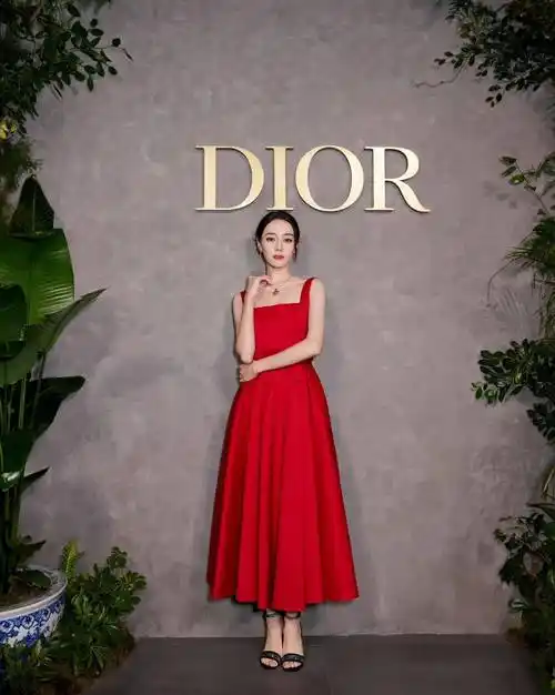 迪丽热巴出席某品牌活动看展,穿了一条小红裙,十分明艳动人,大红色的