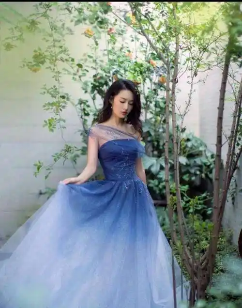 赵丽颖出席活动的一袭蓝色礼服裙运用了蕾丝元素,拖地裙摆拼撞感更上