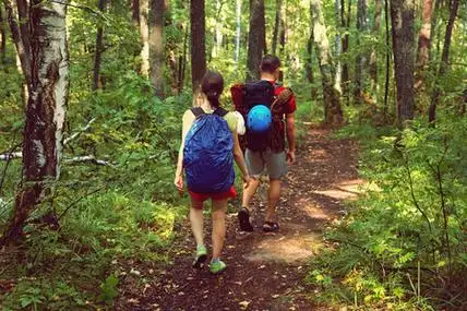 运动的男人和女人背着背包在路上行走照片