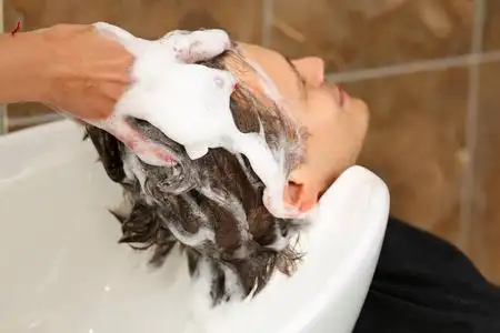 女手洗头发到英俊的男人微笑着年轻美丽的金发女商人