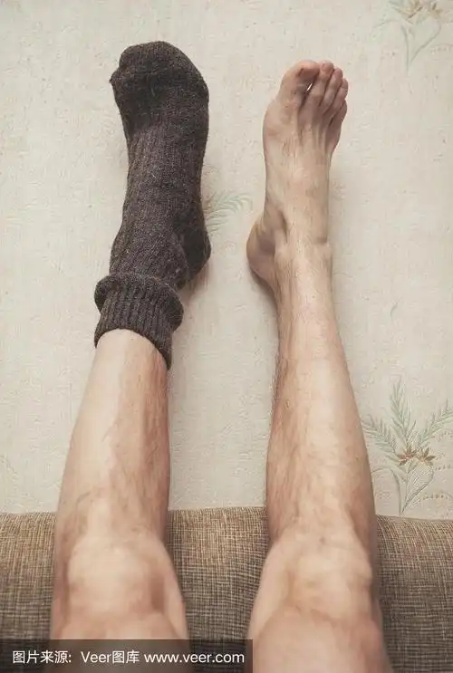 一个穿着羊毛袜子的男人的脚挂在墙上