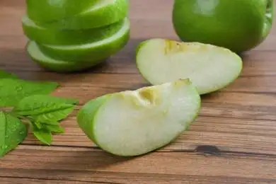 放在木纹背景上切开的青苹果