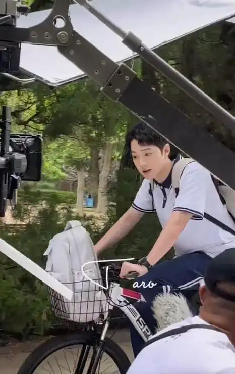 路透中的赖冠霖穿着校服,骑着脚踏车背着书包在人群中穿梭.