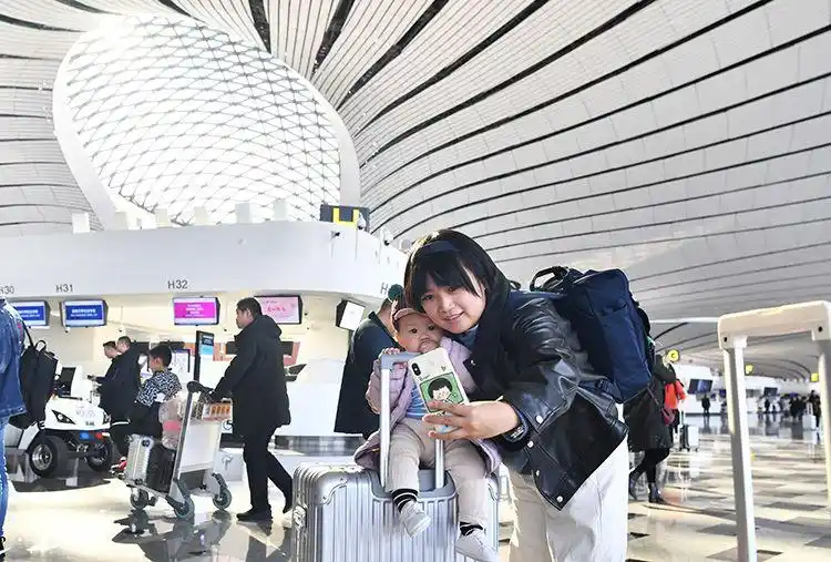 昨日,北京大兴国际机场,一名乘客在机场航站楼内和宝宝自拍.
