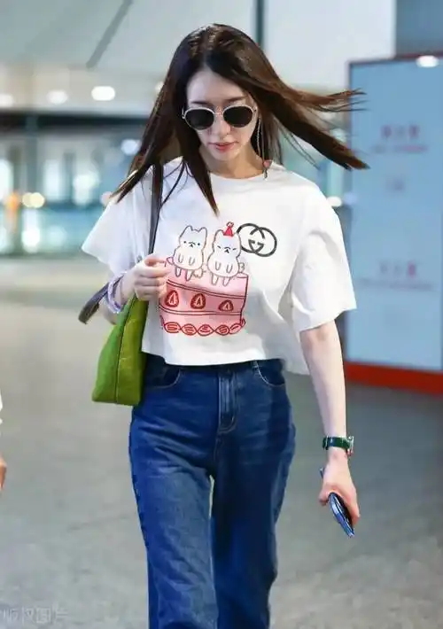 冷白皮的李小冉机场造型很清新,白色卡通t恤衫搭配蓝色牛仔裤,时髦