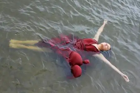 有魅力的女孩玩得开心,潜水和在海水淹死了.红色裙子的女人肖像照片