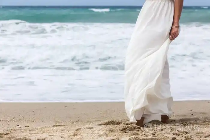 女人在沙滩上的白色连衣裙