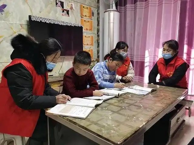 志愿者们正在给郝洋露,郝洋杰小姐弟"一对一"功课辅导.记者陈正 摄