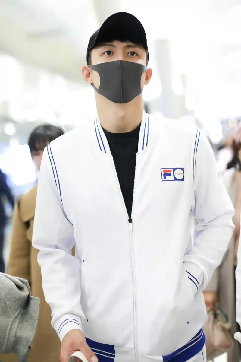 黄景瑜穿白色运动装现身机场,戴黑色棒球帽和口罩遮面