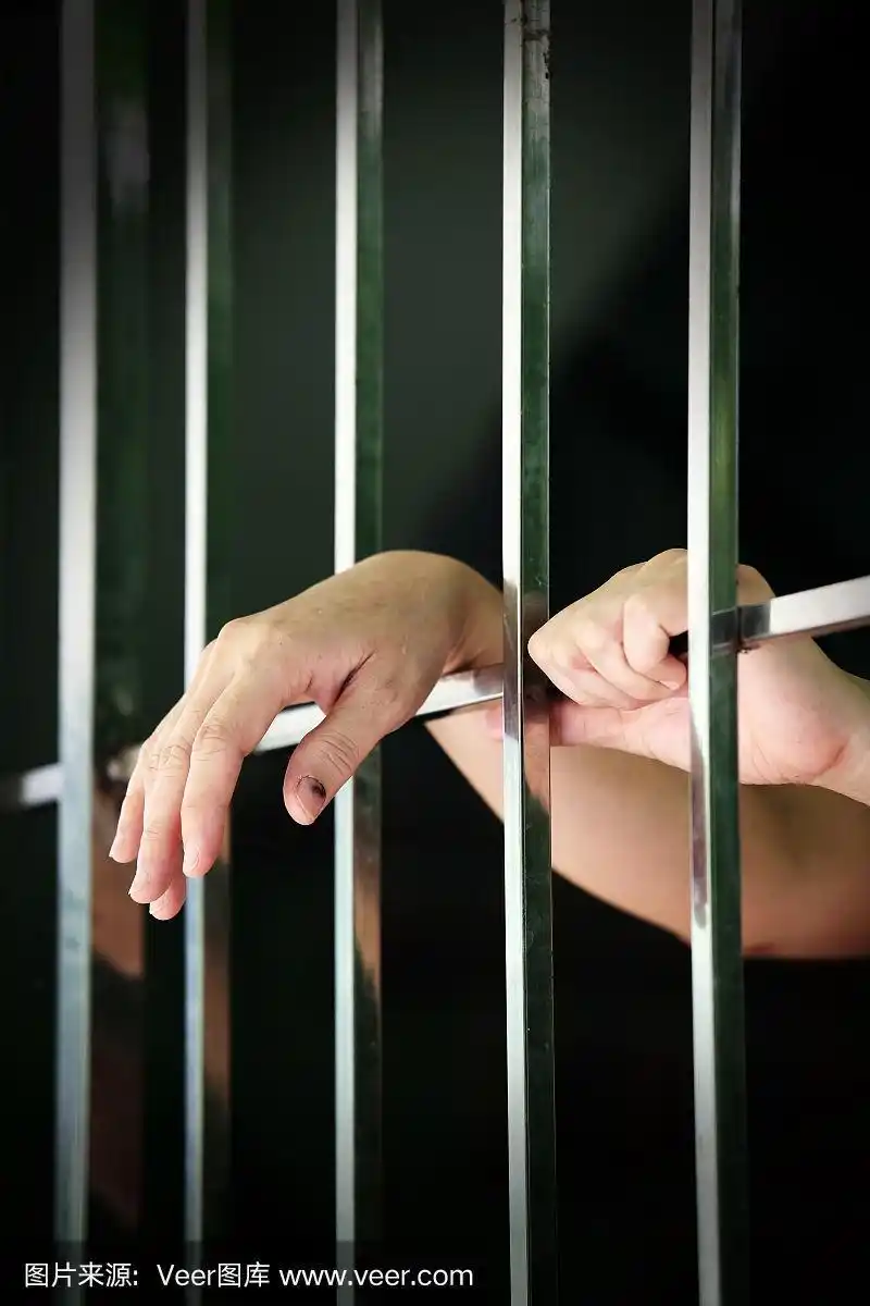 监狱背景中囚犯双手的特写