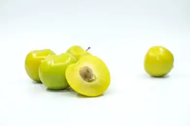 白色背景下切开的绿色李子