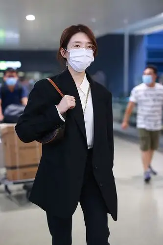 她身穿黑色西装配黑色皮鞋又美又飒. 江疏影边走边甩包.