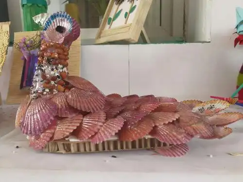 瞧 ——普通的扇贝壳,经过巧手的设计成了栩栩如生的孔雀,惹人喜! !