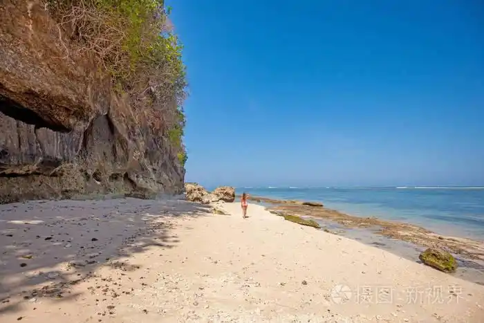 海滩上穿着粉色泳衣的年轻女子的背影照片-正版商用图片16czek-摄图新