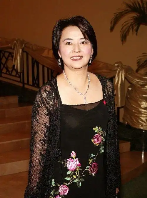 胡慧中身材发福,穿红色旗袍配帆布鞋,脸上皱纹满面还是很有气质