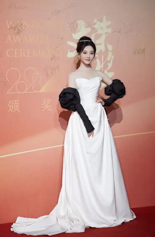 法国梧桐下,@祝绪丹bambi一袭白缎面墨色玫瑰礼服袅袅摇曳,漾开一抹