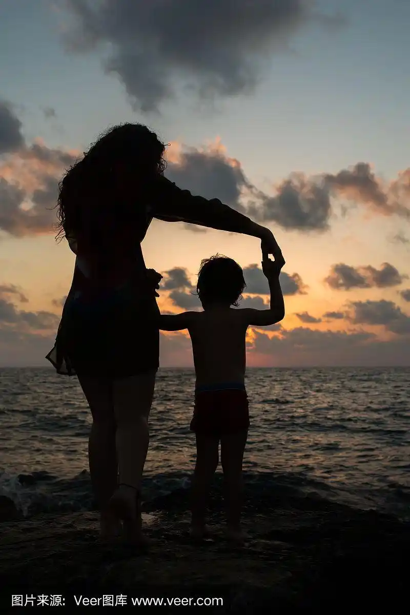 一个母亲和孩子在日落的背影.